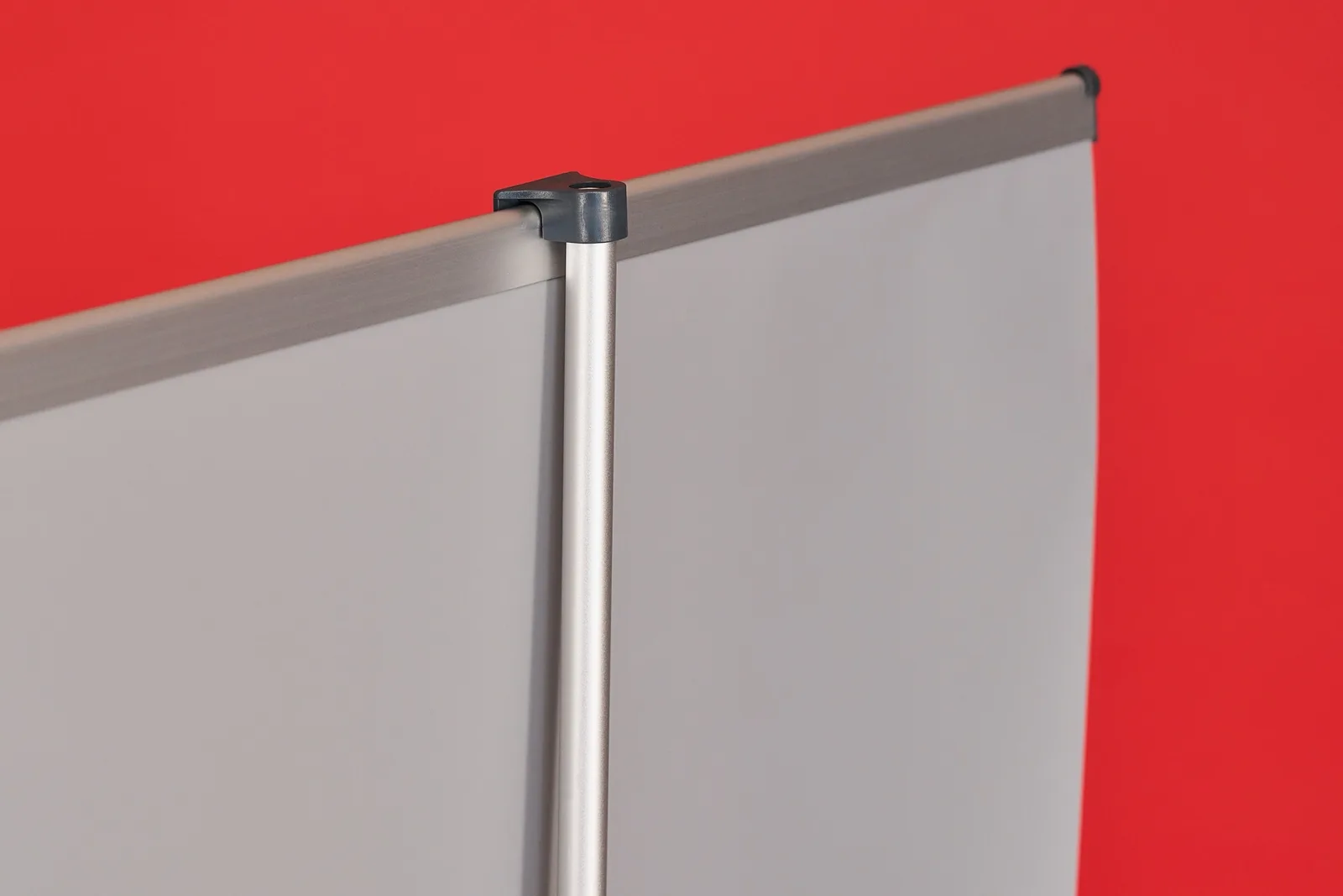 detail of a support pole of a classic roller banner clipped onto the top support pole on a bright red background