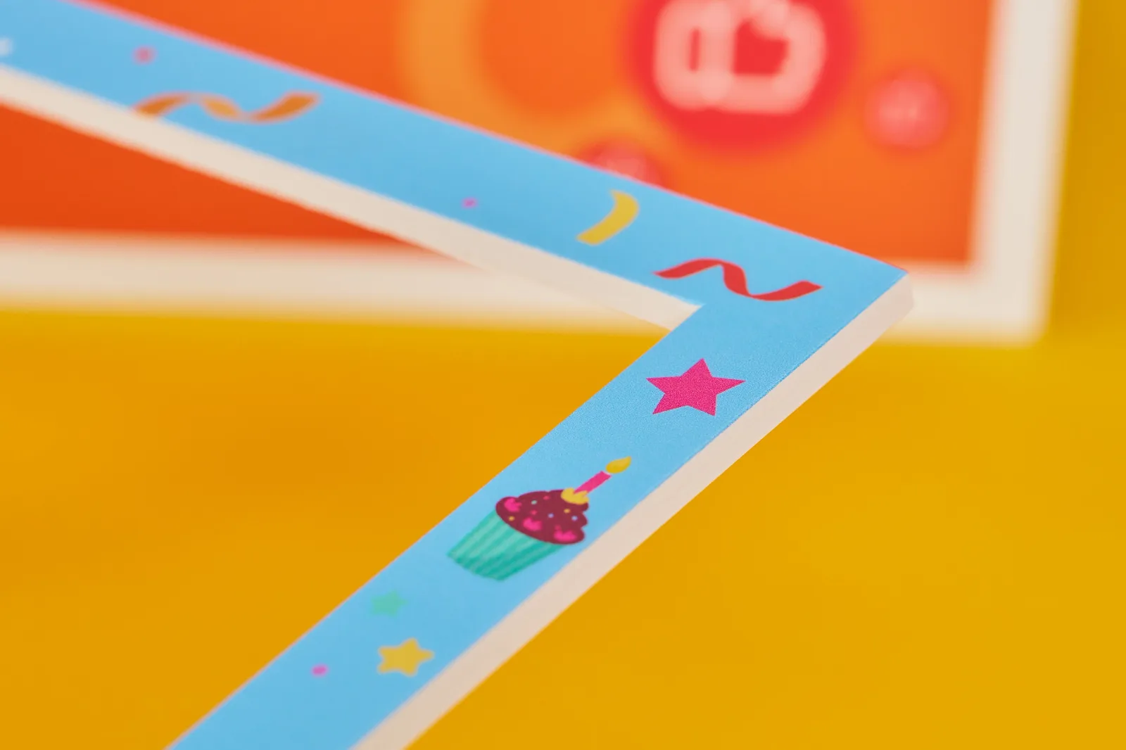 close up of a blue customised selfie frame showing detail of foamex with orange and white selfie frame in background on a bright yellow background 