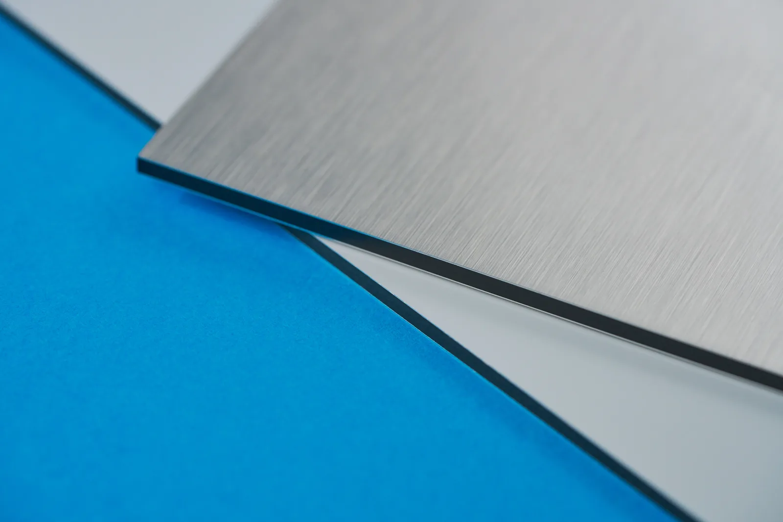 Close up of a white aluminium and brushed aluminium dibond sign on a bright blue background