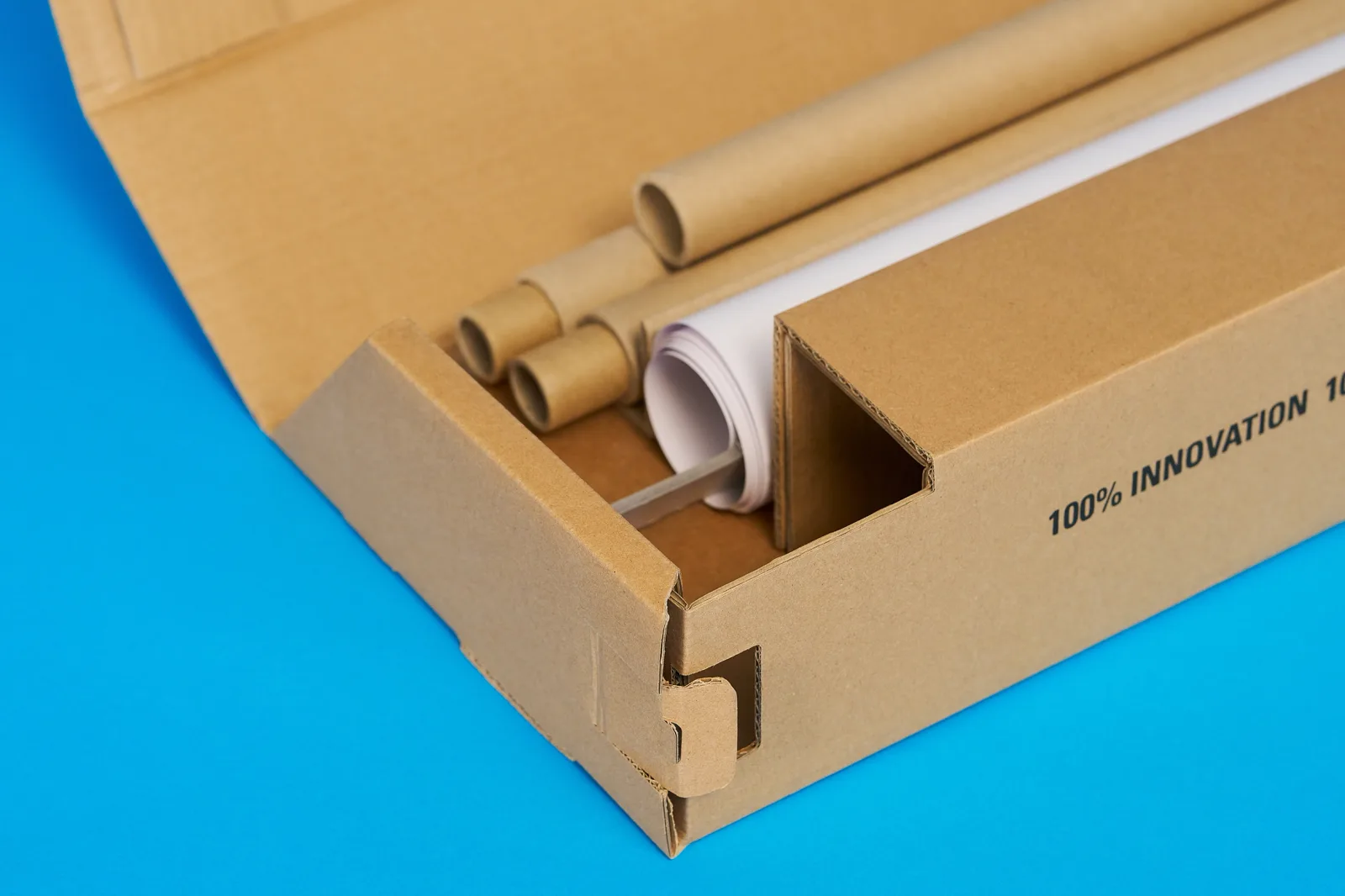 all components of a eco friendly roller banner neatly stored in a cardbaord base on a bright blue background