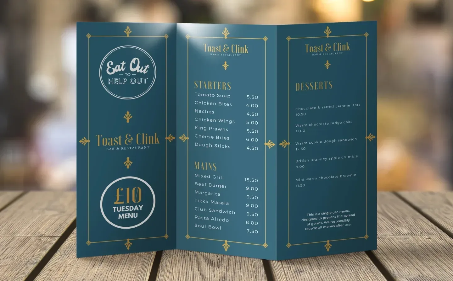 A folded menu in blue and gold, adorned with an elegant gold border, on a wooden table