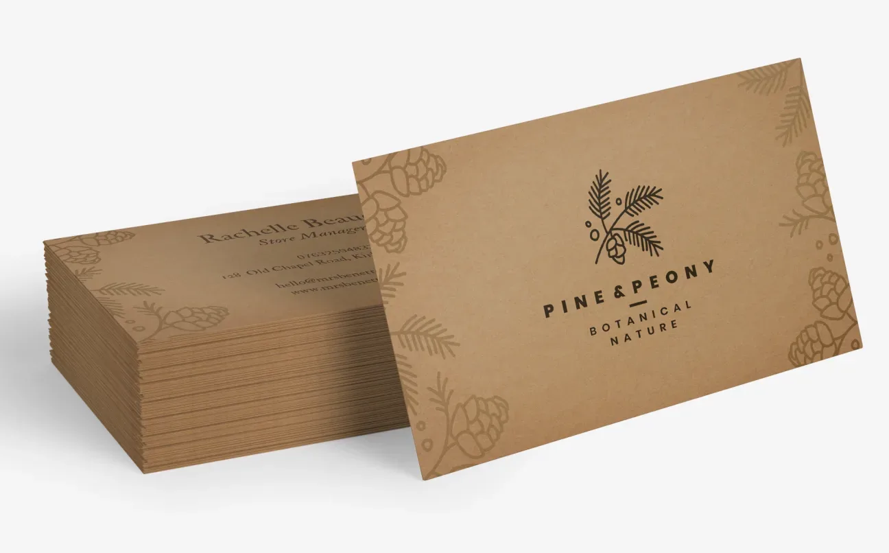 A set of kraft business cards featuring a business logo with a minimal botanical design 