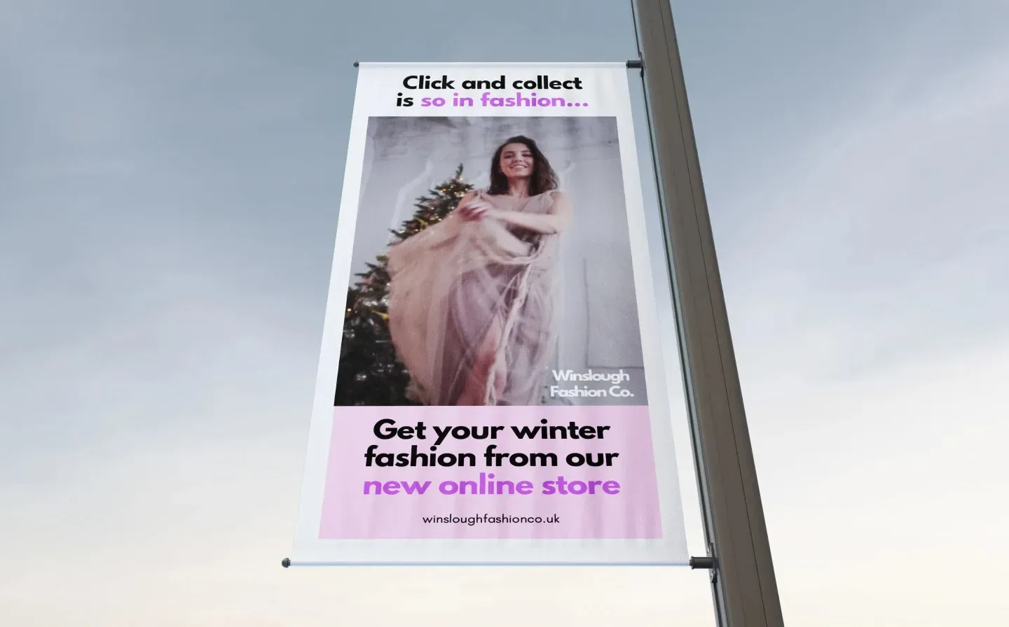 A lamp post banner displays a woman in a dress, advertising the launch of a new online store