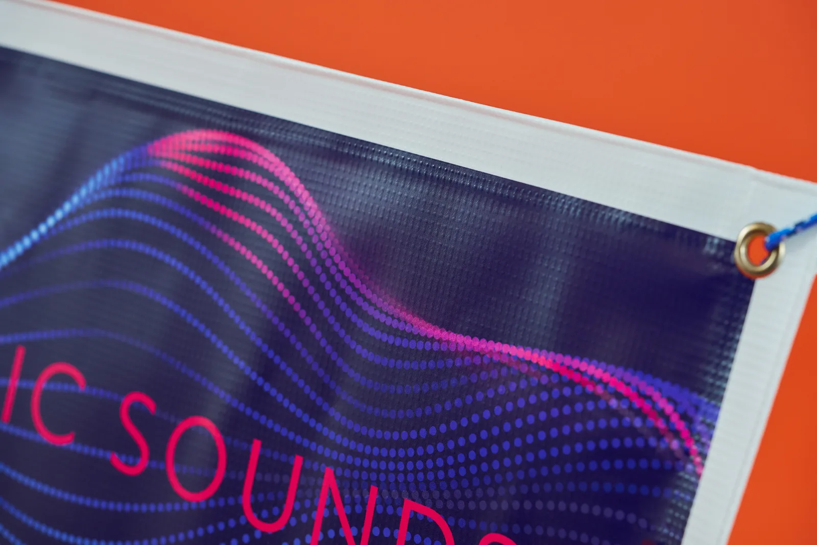 blue and pink printed outdoor pvc banner with eyelet and the word 'sound' on a bright orange background