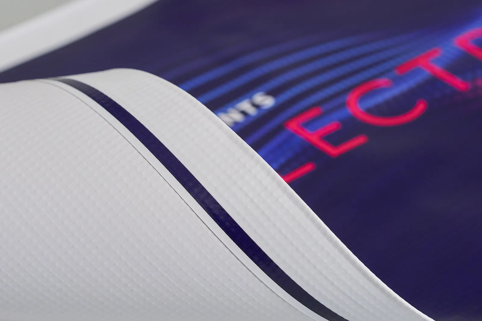 close up of a blue outdoor pvc banner rolled to show the detail of the material