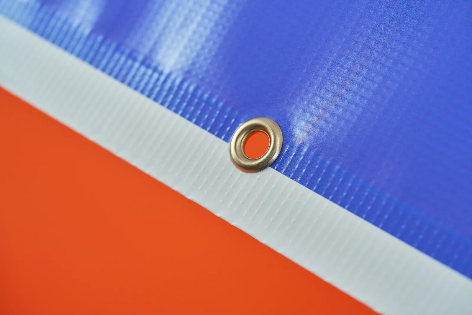 blue and white printed outdoor pvc banner with eyelet on a bright orange background