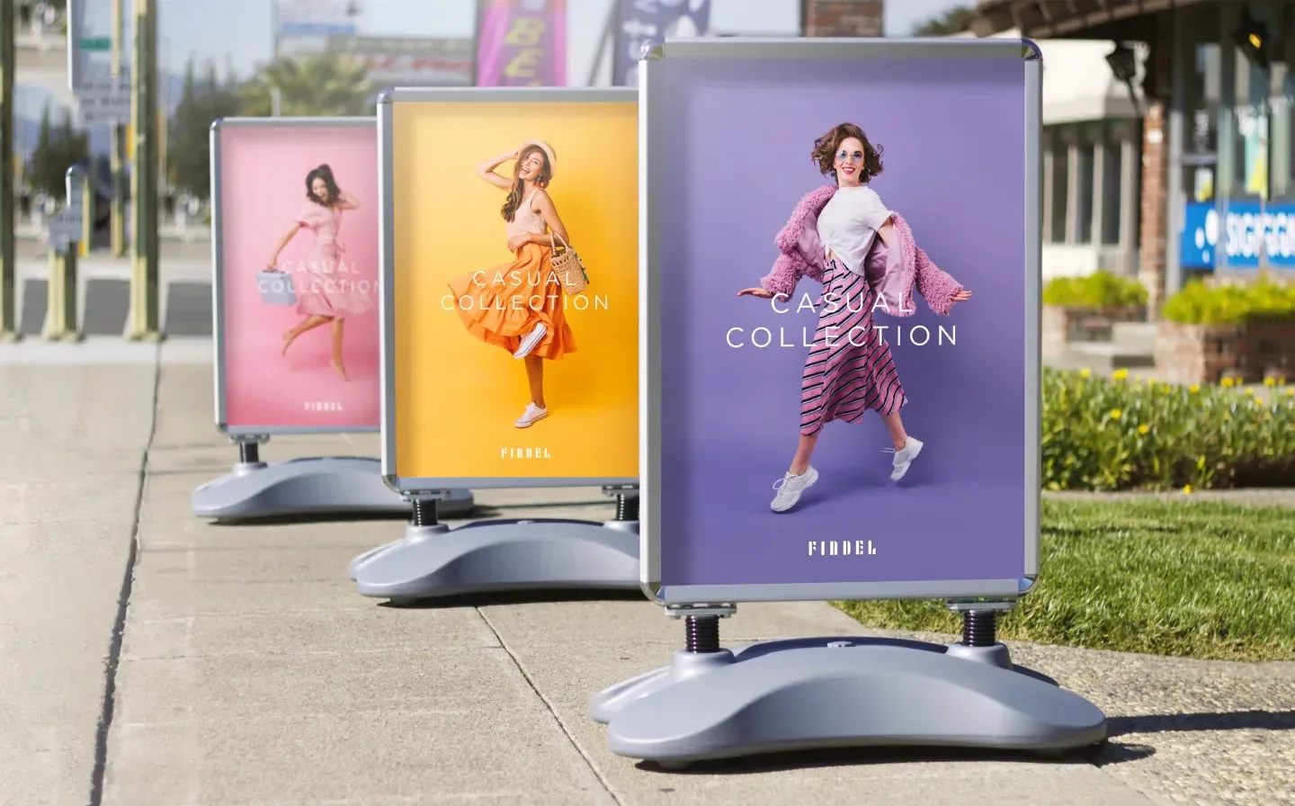 A trio of large pavement signs, promoting a seasonal clothing sale to passersby