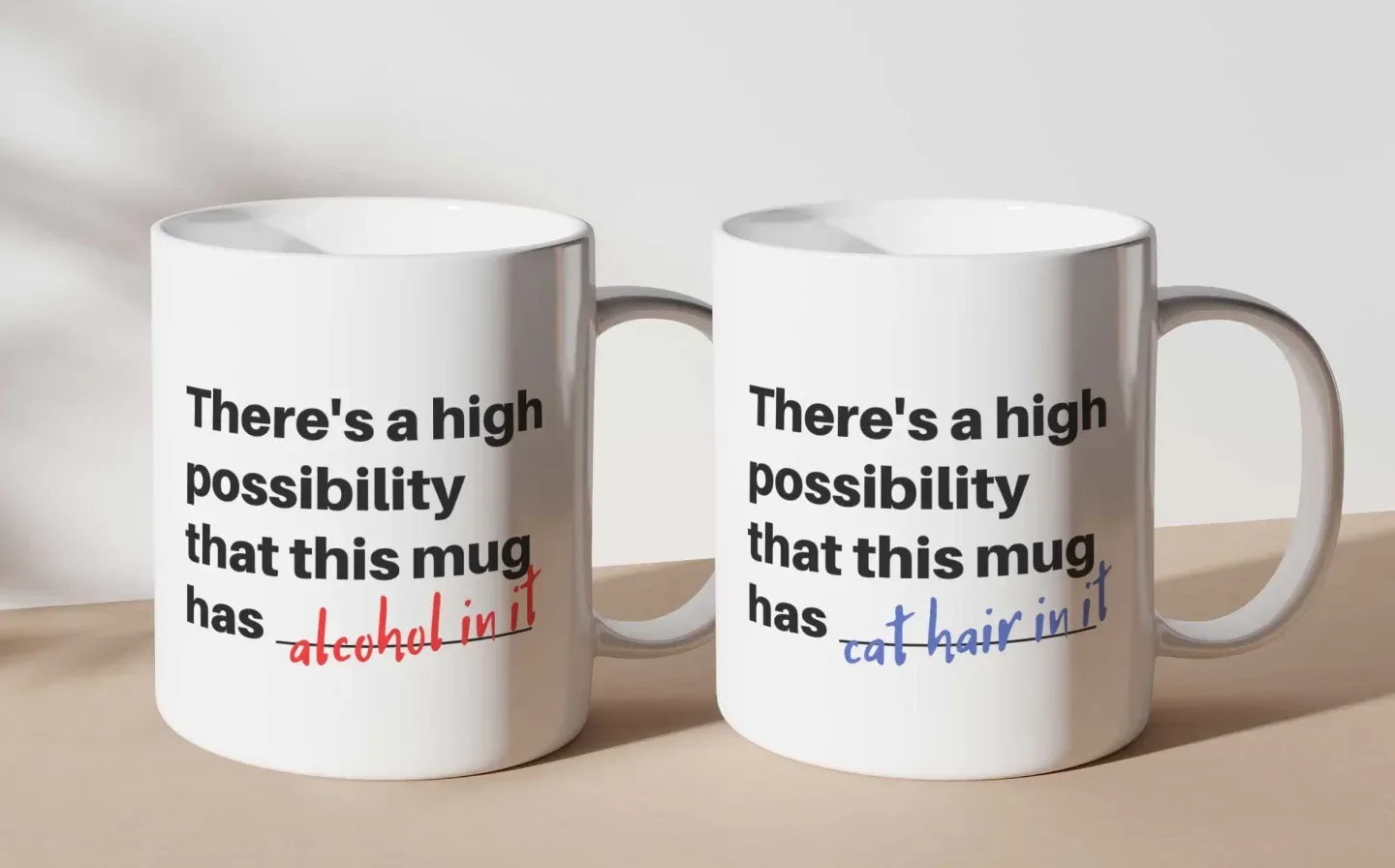 Two large mugs displayed on a desk with humorous phrases in red and blue