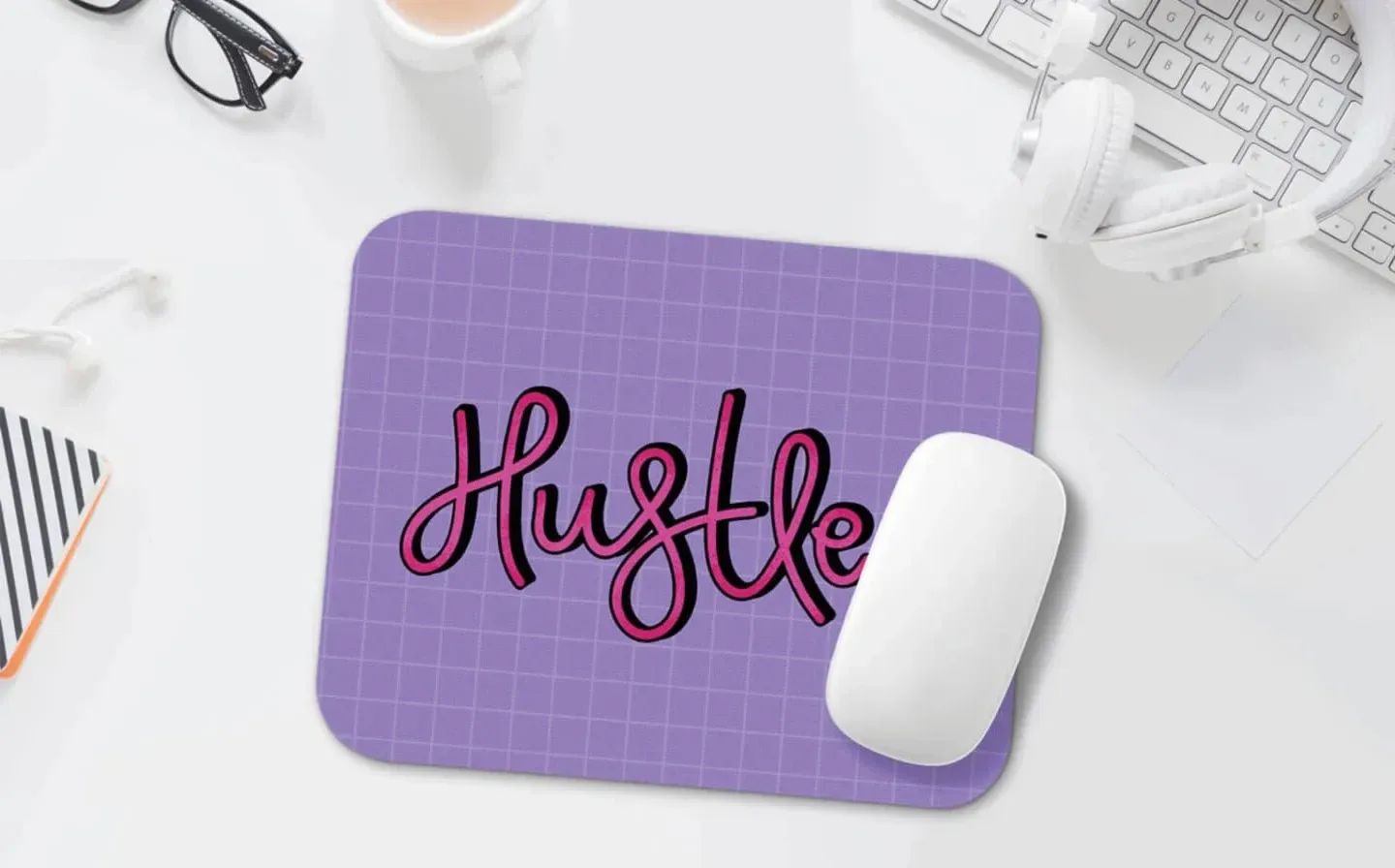 A mouse pad featuring the word "hustle" prominently displayed on a desk surface