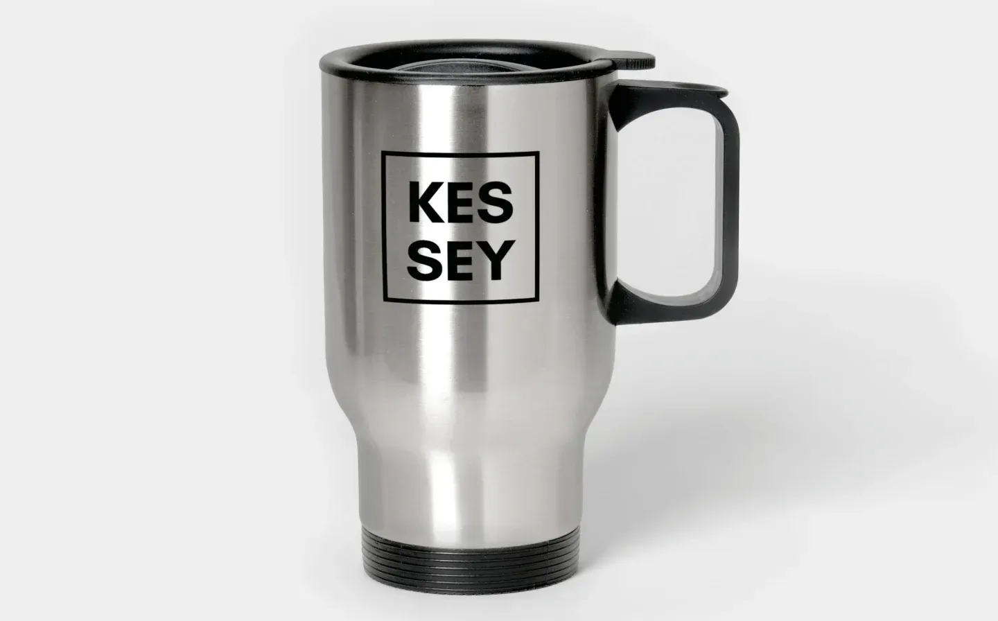 A stainless steel travel mug with "KES SEY" displayed on the surface
