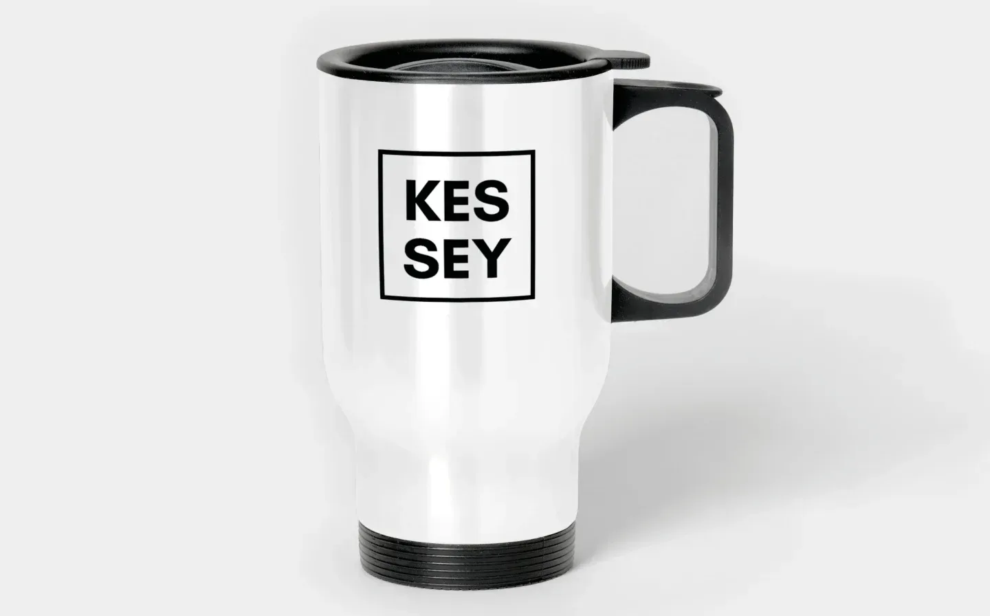 A sleek white travel mug with the words "KES SEY" displayed on its surface