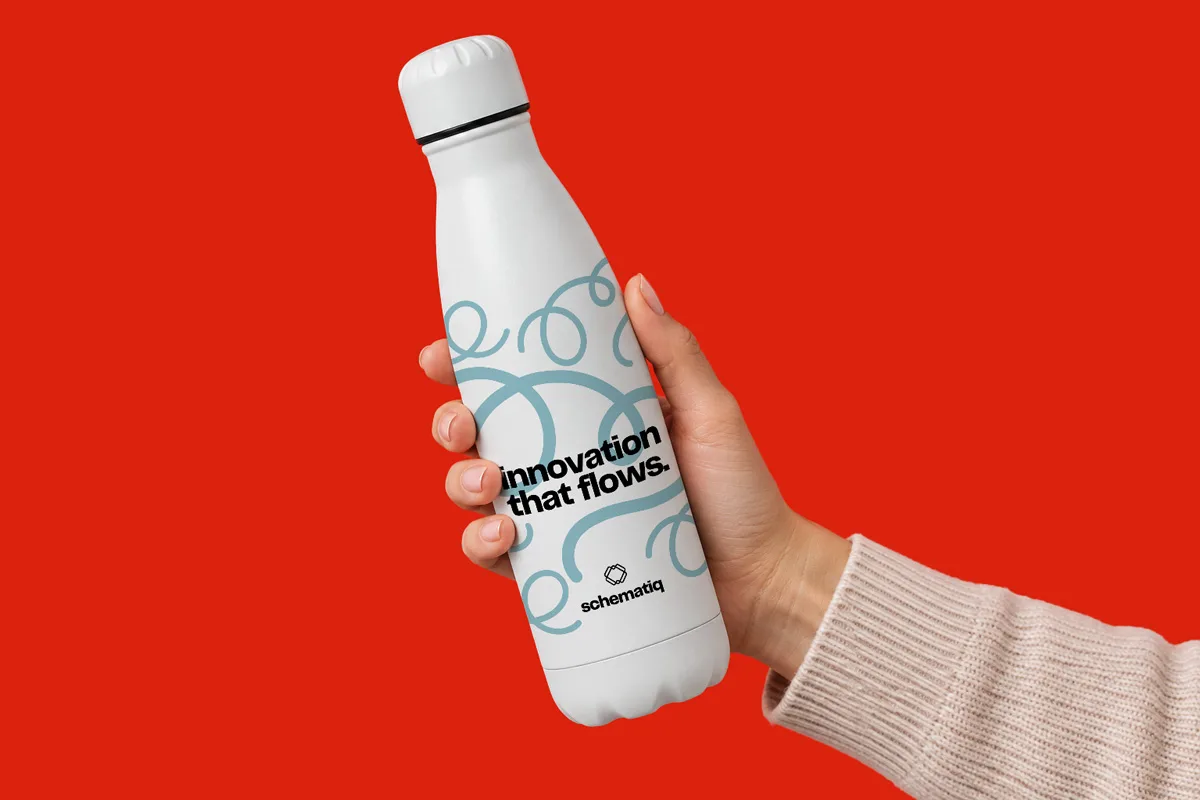 Hand holding a white water bottle labeled “Innovation that flows.” against a red background.