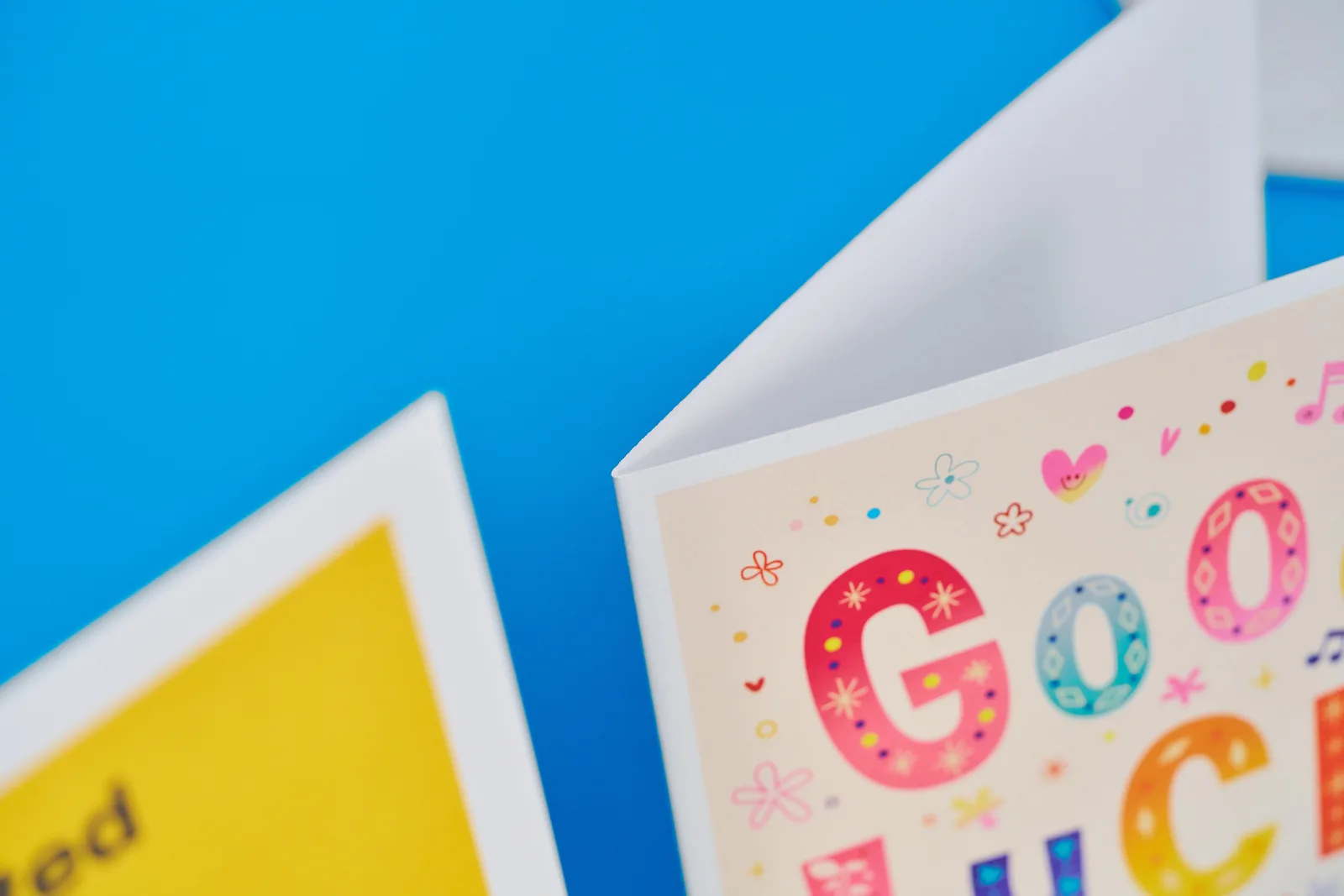 detail showing the fold of a printed greeting card on a bright blue background