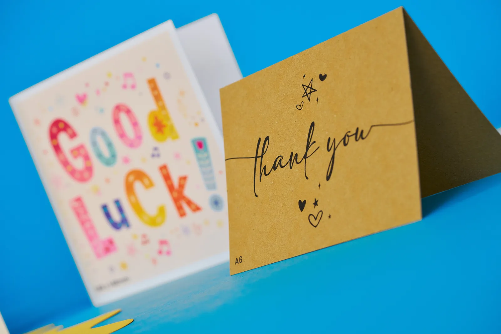 greeting card with text 'good luck' and a kraft paper greeting card with the text 'good luck' on a bright blue background