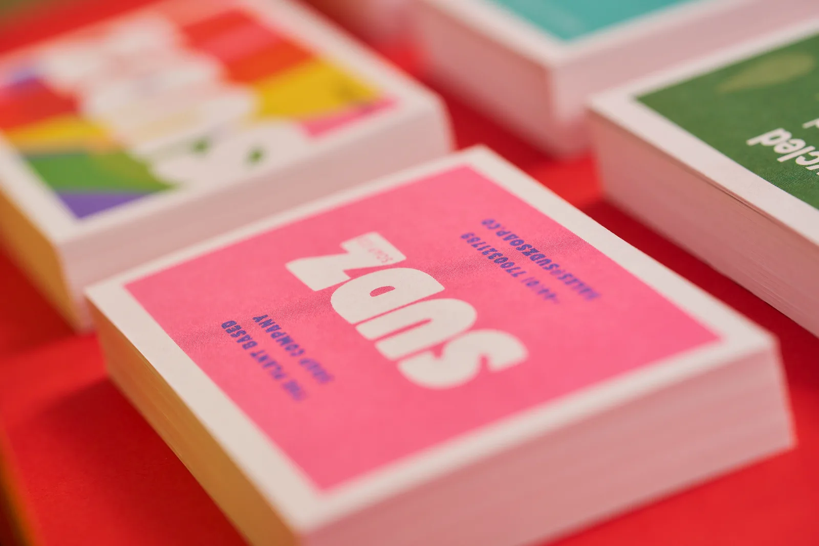 4 stacks of recycled business cards with copy 'sudz' on bright red background