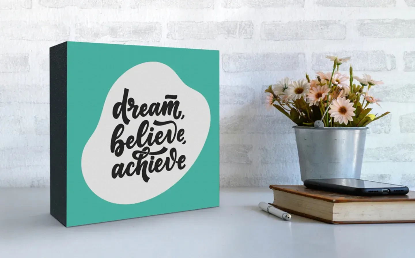 A wooden photo block featuring the inspirational words "dream, believe, achieve"