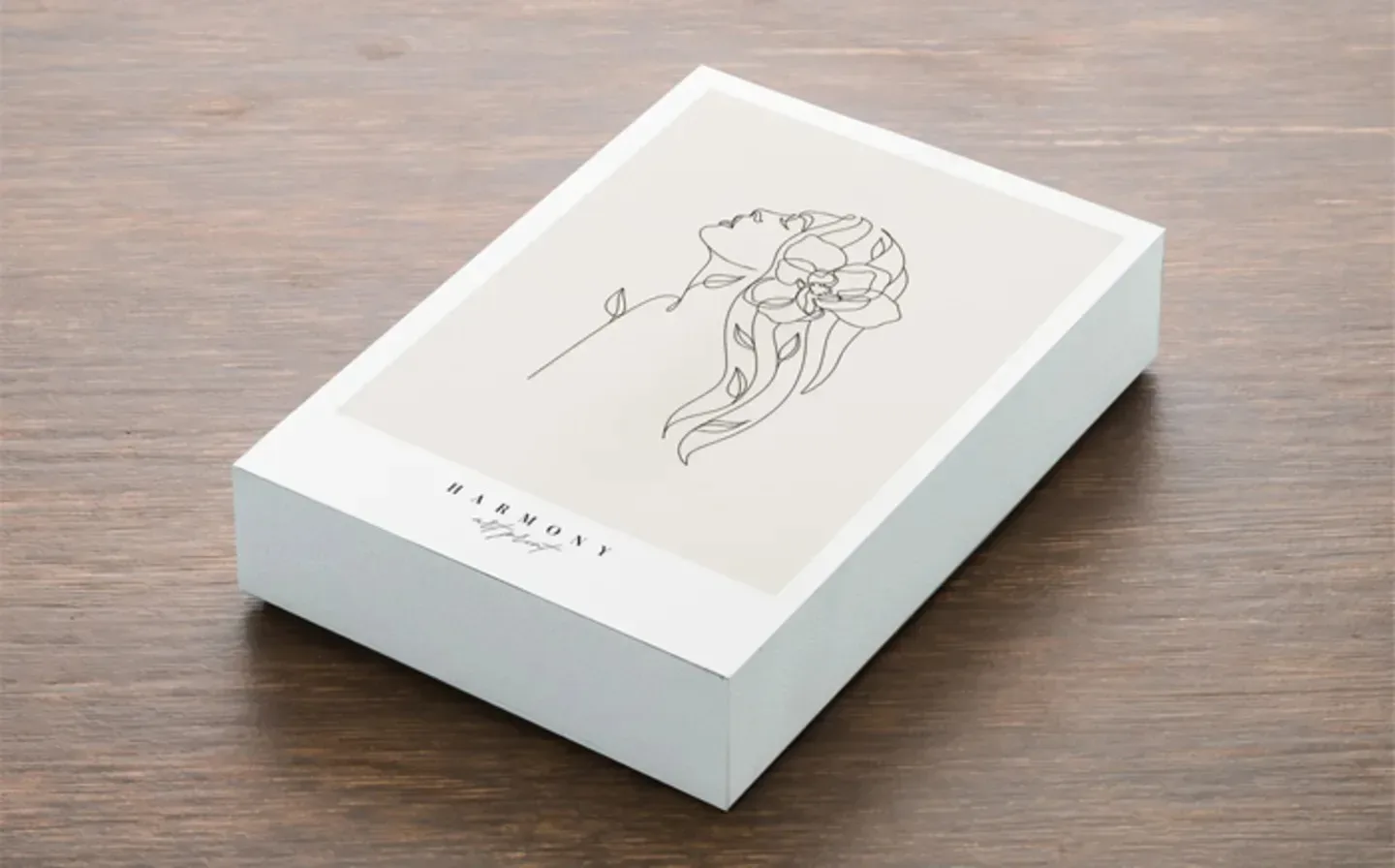 A wooden photo block featuring a line drawing of a woman adorned with flowers in her hair